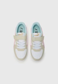 Baskets Puma avec un design beige clair, blanc et rose. Comprennent une sangle velcro, du cuir texturé et une pointe perforée pour la respirabilité.