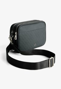 Borsa rettangolare nera con superficie testurizzata, chiusura a doppia zip e tracolla nera regolabile. Gli accessori in argento arricchiscono il design.