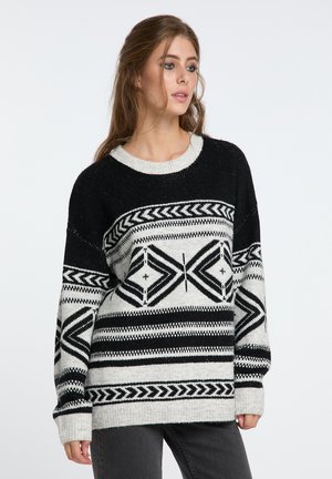 Übergroßer schwarz-weißer Pullover mit geometrischen Mustern, runder Halsauschnitt und gerippten Bündchen. Stricktextur mit kontrastierenden Designs.
