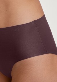 Dunkelbraune, hochgeschnittene Unterwäsche aus glattem Stoff, mit nahtlosem Design und einem minimalistischen Logo am Bund.