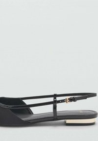 Black flat shoe with thin straps and a gold-accented block heel. Smooth material with pointed toe design and minimalistic style.