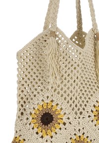 Hæklet netpose i creme med et solsikkemotiv i gule, brune og beige nuancer; inkluderer flettede håndtag og kvaster.