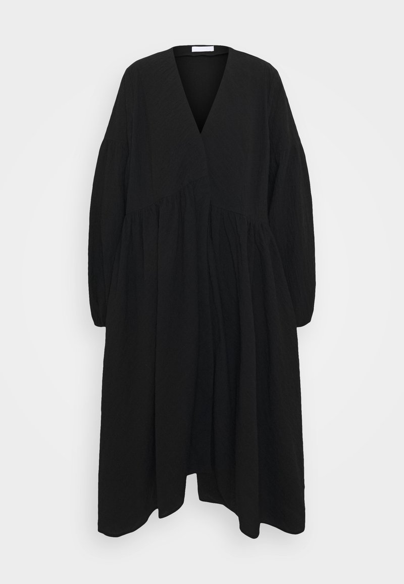 Svart långärmad klänning med V-ringning, rynkad midja och flytande silhuett. Tillverkad av lätt, strukturerad tyg.