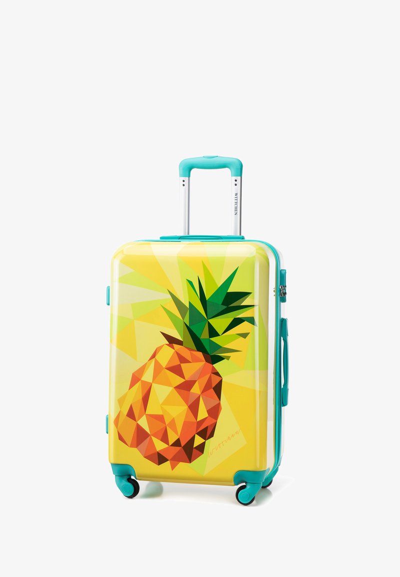 Kufr s pevným pláštěm zdobený geometrickým designem ananasu na žlutém pozadí, doplněný tyrkysovými rukojeťmi a koly.