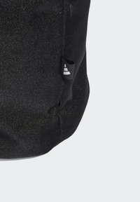 Black fabric bag featuring a textured finish, with a small logo label on the side. Compact design with a rounded shape.