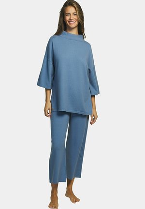Ensemble de vêtements d'intérieur bleu clair comprenant un haut à coupe décontractée avec un col montant et des manches larges, associé à un pantalon à jambe droite en tissu identique.