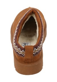 Pantofole in suede marrone con punta rotonda, bordo decorativo intrecciato, morbida foderatura beige e suola robusta modellata.