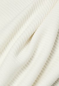 Tissu en coton tissé de couleur blanc cassé avec un motif côtelé texturé. Doux, flexible, avec des rayures alternant entre lisses et en relief.