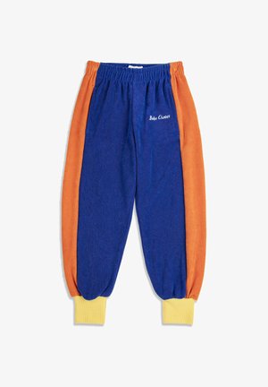 Pantalones jogger de forro polar azul y naranja con puños acanalados amarillos y cintura elástica, con "Bobo Choses" bordado en el bolsillo delantero.