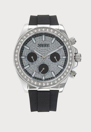 Сребърен часовник Guess с черна силиконова каишка, ог bezel и циферблат, инкрустирани с кристали, три подциферблата и сребристи индекси и стрелки.