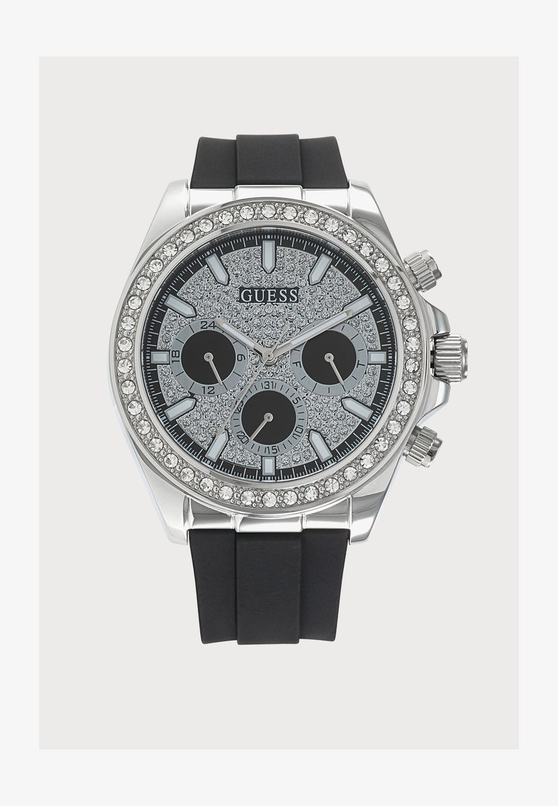 Сребърен часовник Guess с черна силиконова каишка, ог bezel и циферблат, инкрустирани с кристали, три подциферблата и сребристи индекси и стрелки.