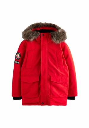 Red parka jacket with a fur-trimmed hood, two front pockets, ribbed black cuffs, and a round logo patch on the sleeve.