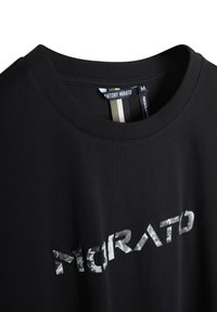 Camiseta de algodón negra con cuello redondo y un logo "MORATO" impreso en blanco y gris en el frontal. Diseño de corte regular.