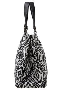 Svart och vitmönstrad väska som är tillverkad av vävd tyg med en hobo-form, som har läderremmar och en texturerad yta.