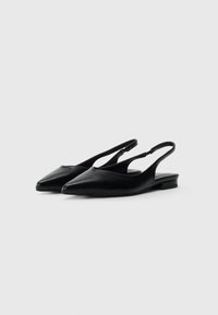 Par kesha crnih kožnih slingback balerinki s oštrim vrhom i niskim potpeticama na bijeloj pozadini.