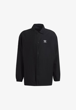 Černá sako na knoflíky vyrobené z látky s hladkou texturou. Má límec, dlouhé rukávy a malé bílé logo Adidas na levém prsu.