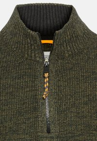 Kragenpullover aus strukturiertem grünem Stoff mit halbem Reißverschluss. Verfügt über einen schwarzen Innenkragen und einen orangefarbenen Akzent am Reißverschlussanhänger.