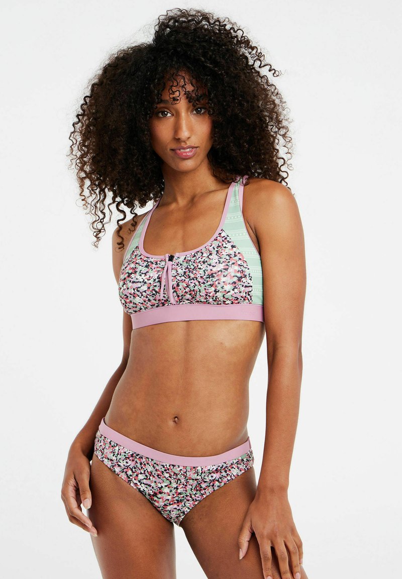 Bikini set s cvjetnim uzorkom koji uključuje top s detaljem u obliku ključa i ružičastim naglaskom, te odgovarajuće donje dijelove s ružičastim pojasom.