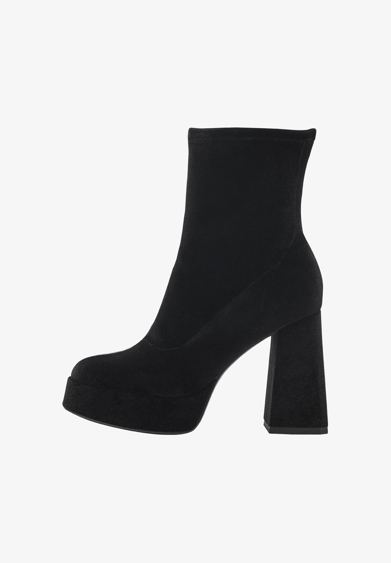 Botines negros de tobillo hechos de suave ante con un alto tacón de bloque y plataforma. Presentan un diseño elegante con mínimos detalles de costura.