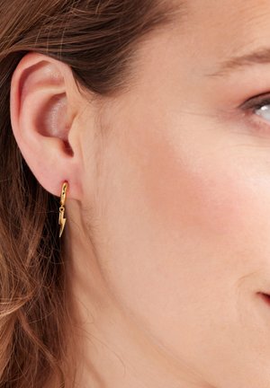 Gouden bliksemflits oorringen, met een gepolijste afwerking. Het ontwerp hangt aan een kleine ring, met een glanzende, gladde textuur.