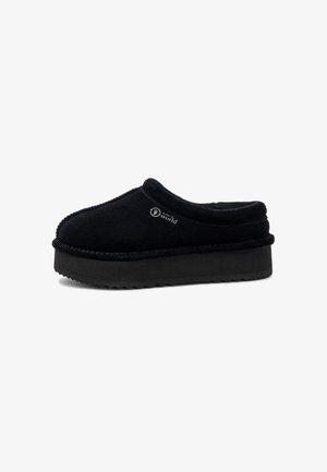 Scarpa slip-on in suede nero con punta rotonda, soletta imbottita e suola piattaforma nera con battistrada testurizzato per una buona aderenza.