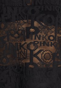 Black lace fabric with a mesh design featuring bold, textured letters and floral patterns, allowing visibility of a lighter background.