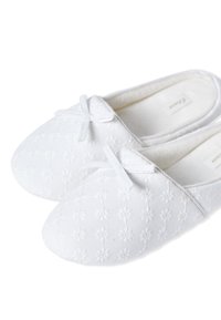Pantofole bianche in cotone con un design ricamato floreale, morbido al tatto e un piccolo fiocco decorativo sul davanti. Forma a punta tonda.