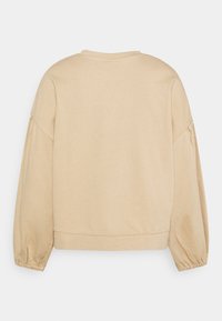 Sweat-shirt court beige avec un col rond, des manches longues bouffantes, des poignets élastiques et une texture douce et lisse.