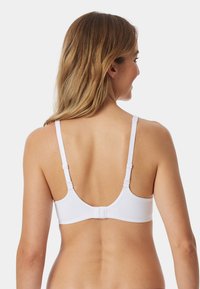 Soutien-gorge blanc avec une texture lisse, des bretelles réglables, une fermeture par crochet et un design simple, vu de l'arrière.