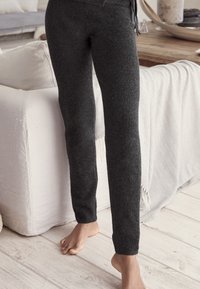 Donkergrijze, zachte wolmix broek met een snug fit, taps toelopende boorden en een elastische tailleband. Gelaagde textuur met een trekkoorddetail.