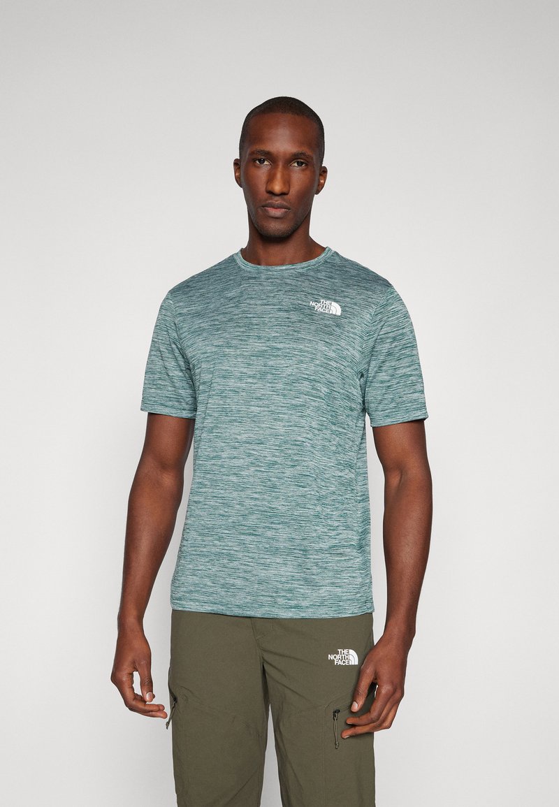 Lühikeste varrukatega spordisärk teallasest melange kangast, ümmargune kaelus, vasakul rinnal valge logo, koos oliiviroheliste cargo-pükstega.