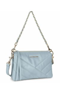 Borsa a tracolla in pelle blu chiaro con tracolla a catena dorata, chiusura con zip, texture trapuntata e un accento con nappina. Presenta il logo del marchio in oro.