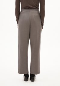 Grijze wijde broek gemaakt van zachte stof, met een soepele tailleband, achterzakdetails en een losse pasvorm. Gemaakt met zwarte schoenen.