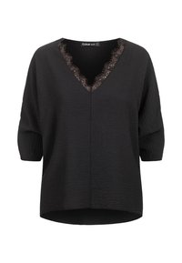 Schwarze Bluse mit V-Ausschnitt und dekorativer Spitzenborte, kurzen Ärmeln und leicht geschwungenem Saum. Strukturierter Stoff mit lockerem Schnitt.