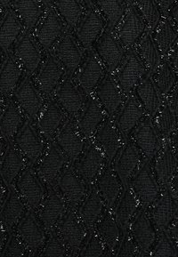 Sort tekstureret stof med et diamantmønster. Overfladen har en let skinnende finish med et hævet, vævet udseende.