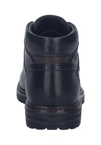 Botín negro de cuero hasta el tobillo con puntera redondeada, collar acolchado, acentos marrones y suela de goma texturizada. Presenta costuras decorativas y perforaciones.
