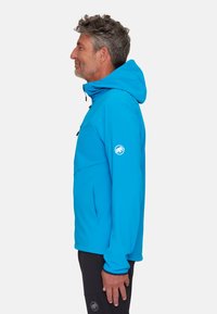 Leuchtend blauer Kapuzenjacke mit glatter Textur, ausgestattet mit einer Reißverschlusstasche, einem Logo am Arm und einer schlanken Silhouette.