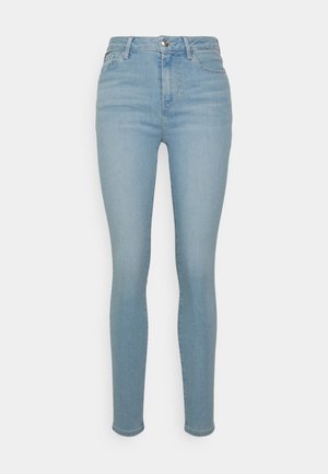 Hellblaue, hoch taillierte Skinny-Jeans mit vorderer Knopf- und Reißverschluss, Gürtelschlaufen und Taschen auf weißem Hintergrund.
