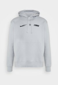 Světle šedá mikina s kapucí, přední kapsou, černým logem Nike a textem na hrudi, šňůrkami na stažení a žebrovanými manžetami a dolním lemem.