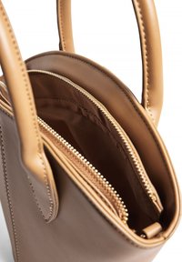 Šviesiai ruda odinė rankinė su dviem rankenomis, turinti užtrauktuką ir tekstūruotą vidinę pamušalą, demonstruojanti nepriekaištingą dizainą.