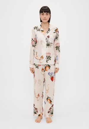 Ensemble de pyjama léger et soyeux aux couleurs claires, orné de motifs floraux et fantaisistes. La chemise possède un col et des boutons, tandis que le pantalon est ample.
