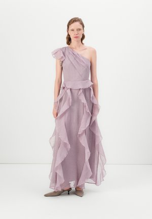 Asymmetrical lavender dress with ruffled layers, lightweight fabric, and one shoulder strap. Paired with gray kitten-heel shoes.