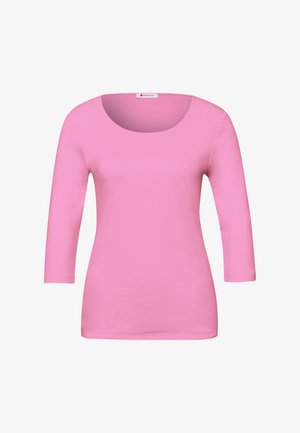 Růžové dámské tričko s dlouhým rukávem, přiléhavé, s kulatým výstřihem a malou značkovou cedulkou na límci.