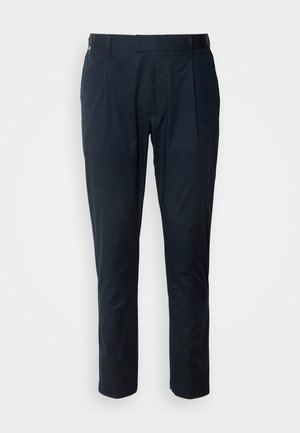 Pantaloni bleu marin cu o textură netedă, având plisuri frontale, o croială ajustată și un brâu cu bucle pentru curea.