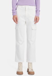 Pantaloni cargo bianchi con tasche laterali, taglio dritto, realizzati in denim. Abbinati a un top viola testurizzato e stivali beige con lacci.