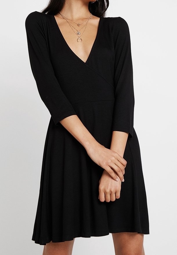 Svart omlottklänning med djup V-ringning, trekvartslånga ärmar och en utställd kjol. Tillverkad av mjukt, stretchigt material med en slät yta.