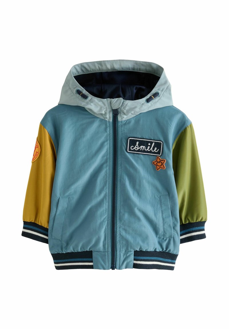 Kleurvolle bomberjack met een blauwe body, groene en gele mouwen, ritssluiting, geborduurde patches, en gestreepte manchetten en onderrand.
