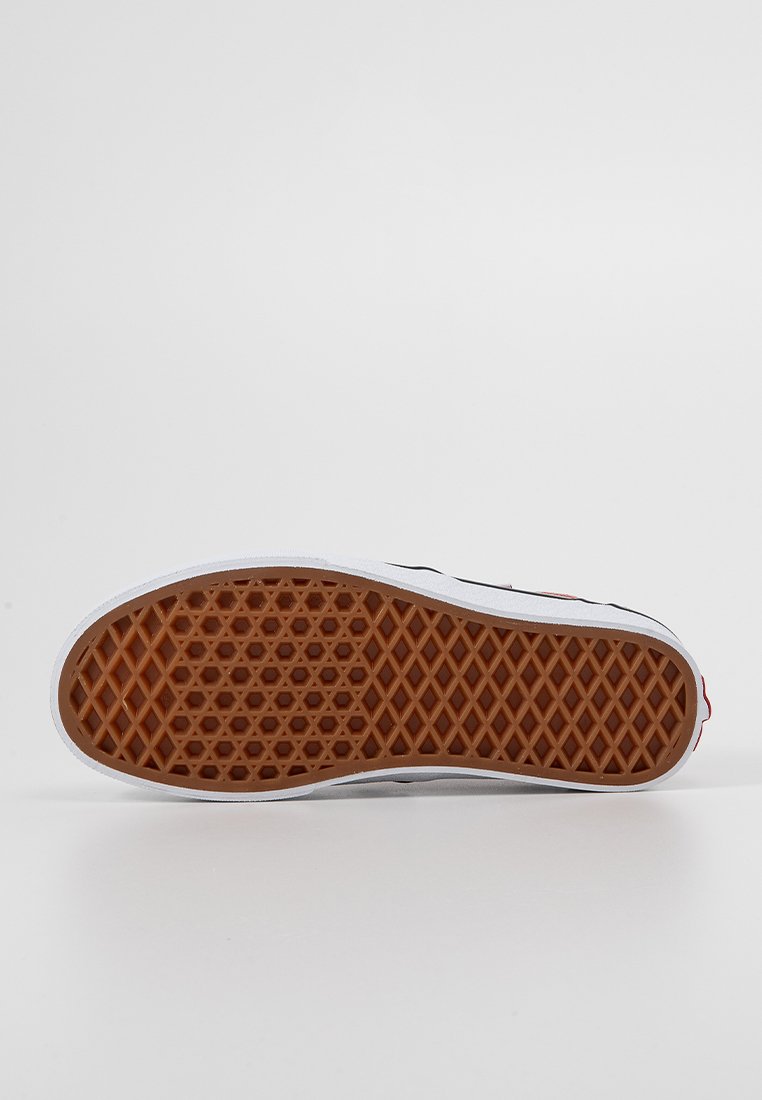 Sole della scarpa con battistrada in gomma marrone a motivo waffle e intersuola bianca, mostrata piatta su uno sfondo bianco.
