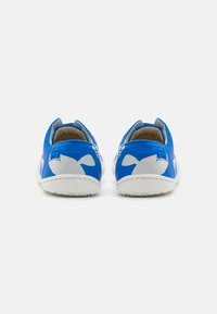 Scarpe in tessuto blu con accenti bianchi, retro arrotondato e suola liscia. Pattern di balene notevoli sui lati.