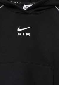Svart hooded tröja i mjukt tyg med en framficka, silverdetaljer och vita "Nike"- och "AIR"-logotyper på bröstet.